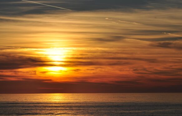 Red sky sun-setting and atmospheric clouds over the sea at Aberystwyth.