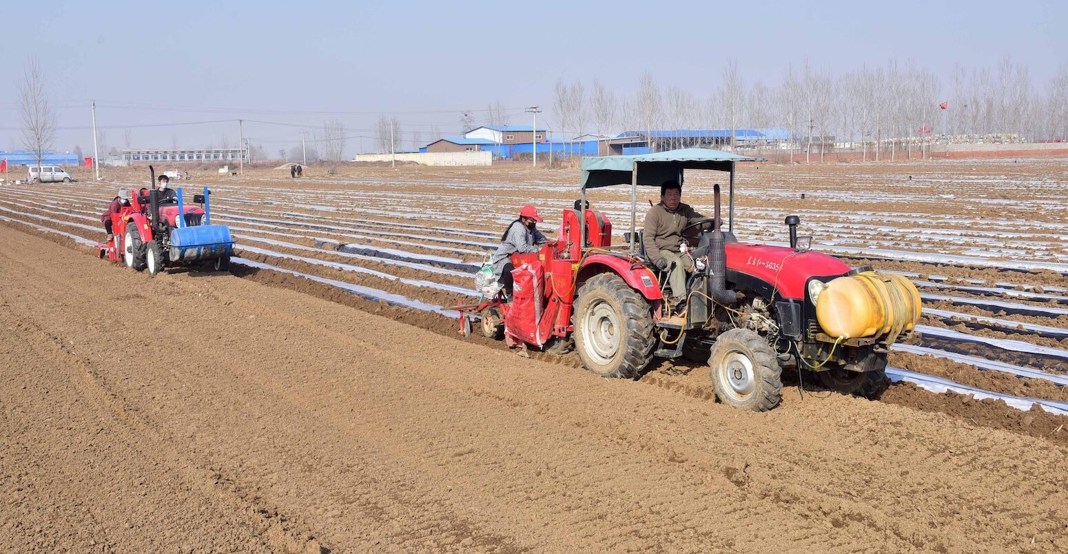 Farmers ploughs land with tractors in Hebei province, China.