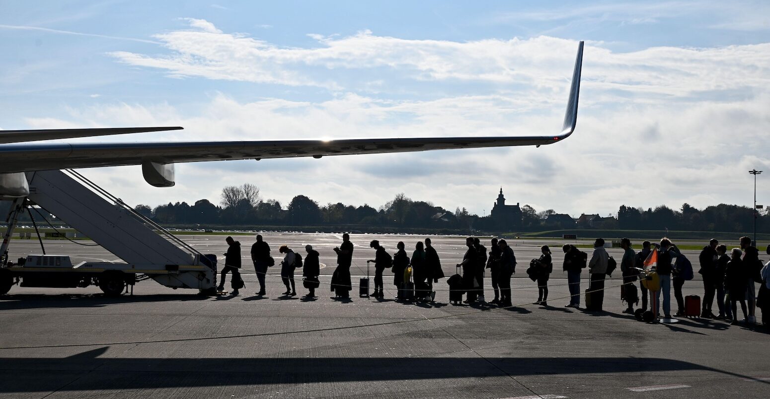 People waiting to get on a plane on the runway. Credit: SJBright / Alamy Stock Photo. Image ID: 2YRJ7J5.