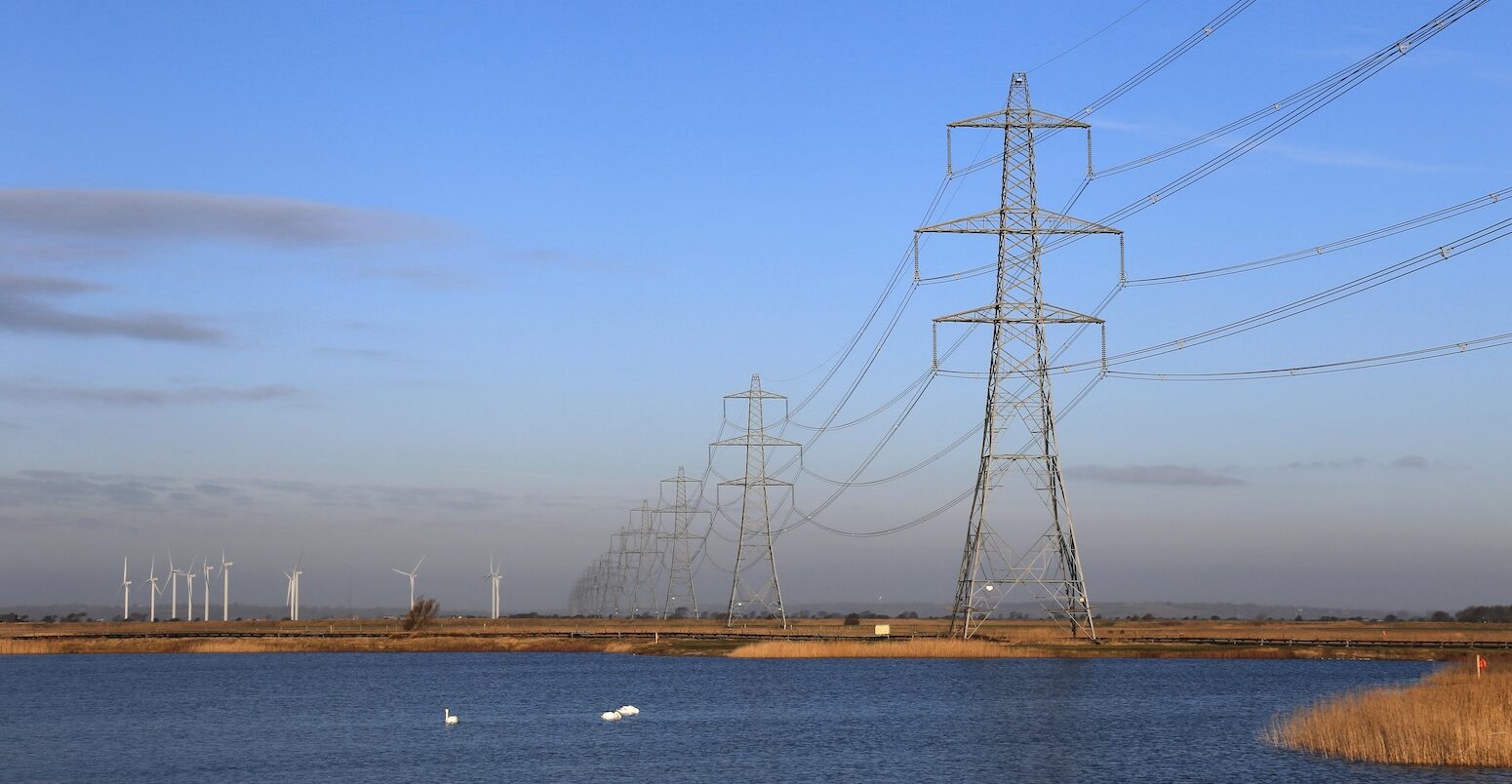 Pylons and wind farm in Dungeness, Kent, UK.