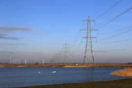 Pylons and wind farm in Dungeness, Kent, UK.