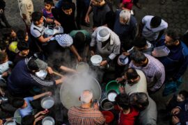 A group of people wait to be served food, Gaza, Palestine.