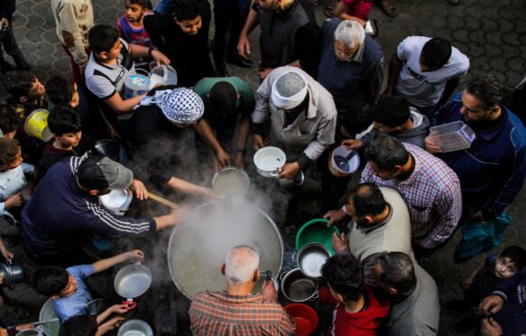 A group of people wait to be served food, Gaza, Palestine.