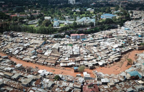 An aerial photo of slums in Kenya with flooding travelling through the middle of the informal settlement.