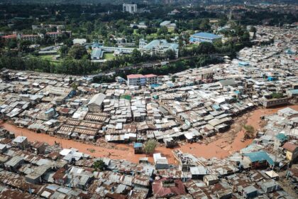 An aerial photo of slums in Kenya with flooding travelling through the middle of the informal settlement.