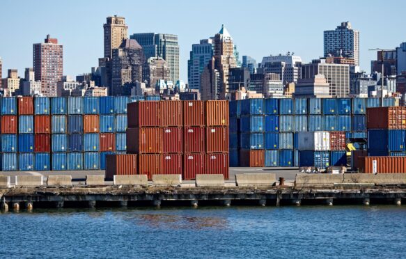 Stacks of shipping containers at Red Hook Container Terminal against Brooklyn skyline, US.