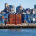 Stacks of shipping containers at Red Hook Container Terminal against Brooklyn skyline, US.