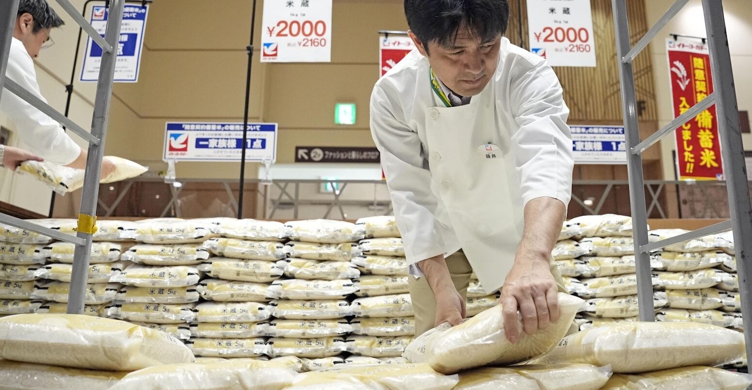 supermarket worker handles bags of reserve rice released from government stockpiles in Tokyo on 31 May 2025.