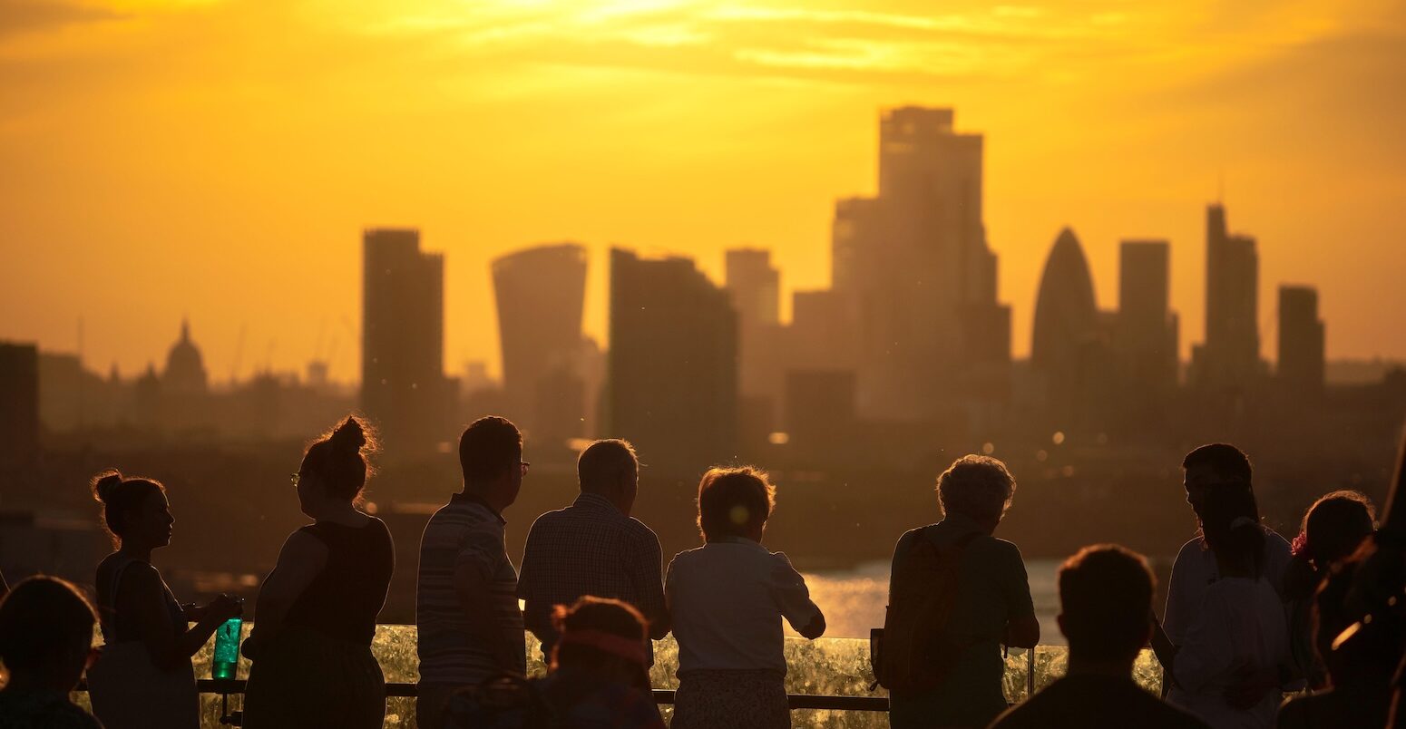 People overlooking London's skyline during a heatwave.
