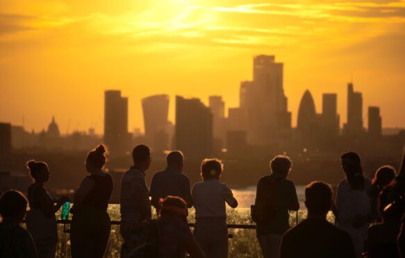 People overlooking London's skyline during a heatwave.