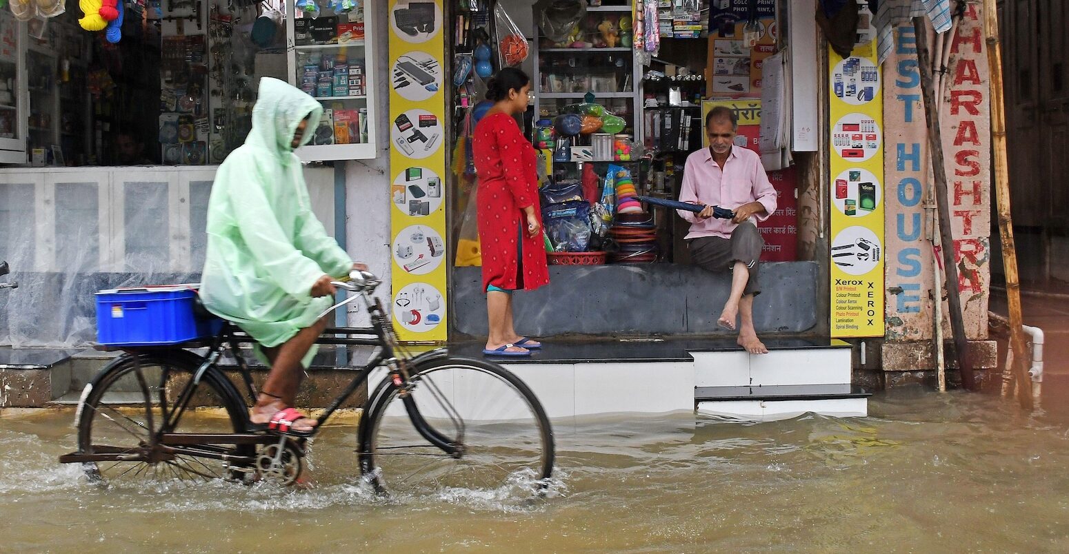 A cyclist goes through heavy rain and flooding in Mumbai, India.