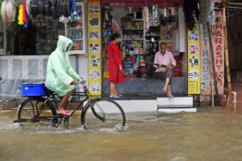 A cyclist goes through heavy rain and flooding in Mumbai, India.