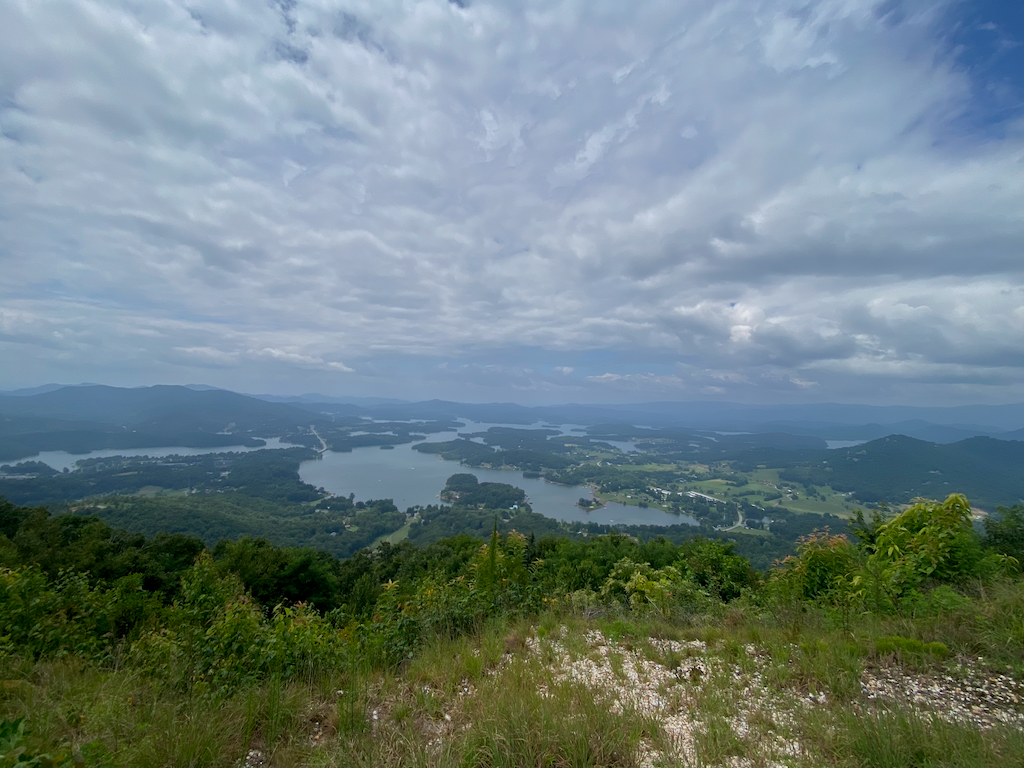 Image taken from Bell Mountain showing a view of Lake Chatuge in the distance, with trees and grass in the foreground.