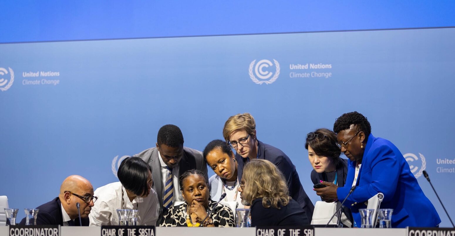 Delegates huddle at a UNFCCC event. Credit: IISD/ENB - Kiara Worth.