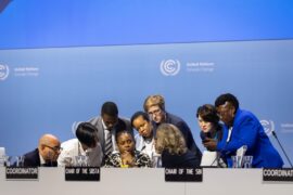 Delegates huddle at a UNFCCC event. Credit: IISD/ENB - Kiara Worth.