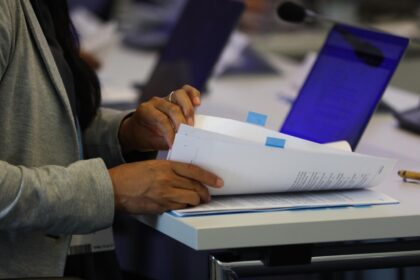 A delegate checks documents at a UNFCCC event. Credit: IISD/ENB - Kiara Worth.