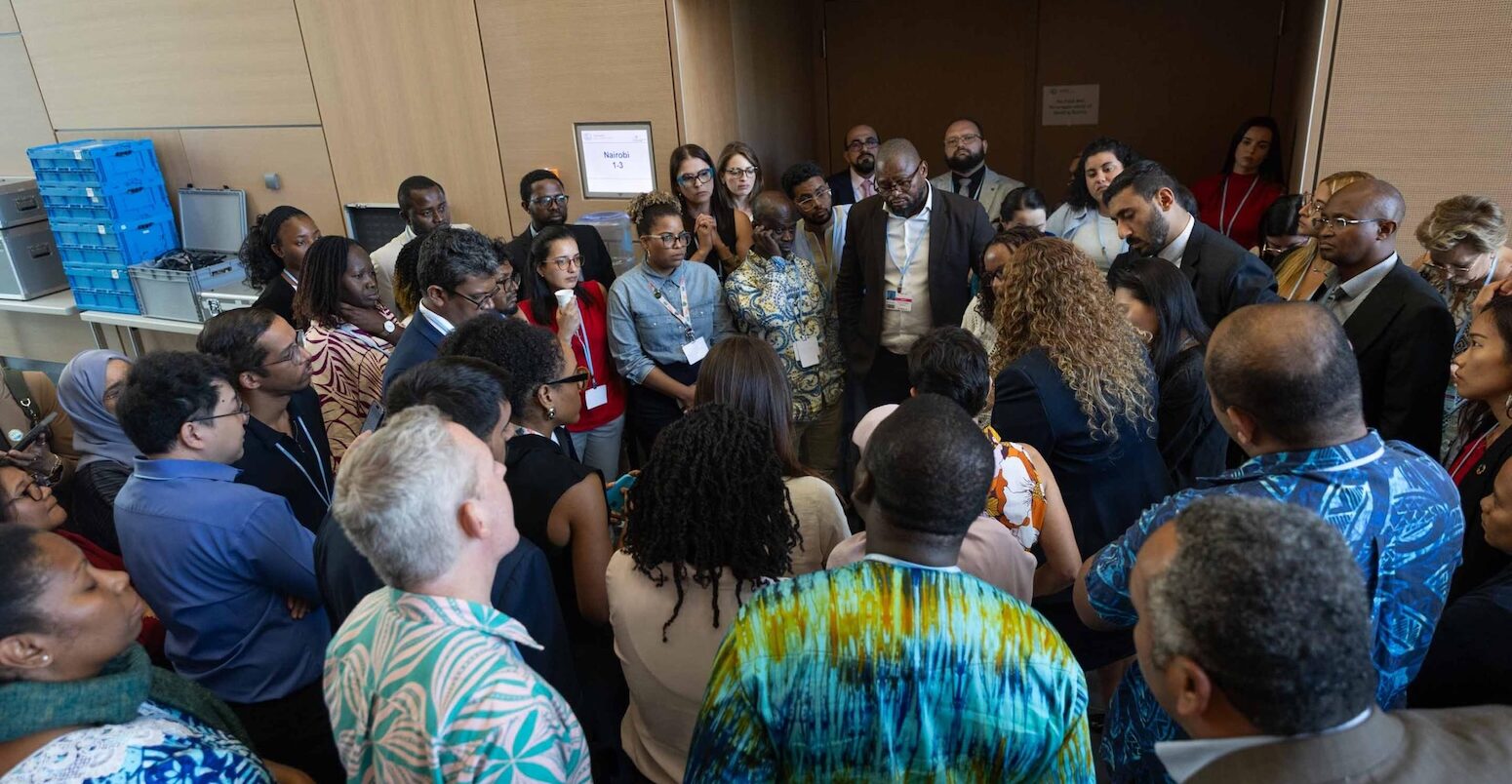 Members of the G-77/China huddle during informal consultations on 19 June 2025.