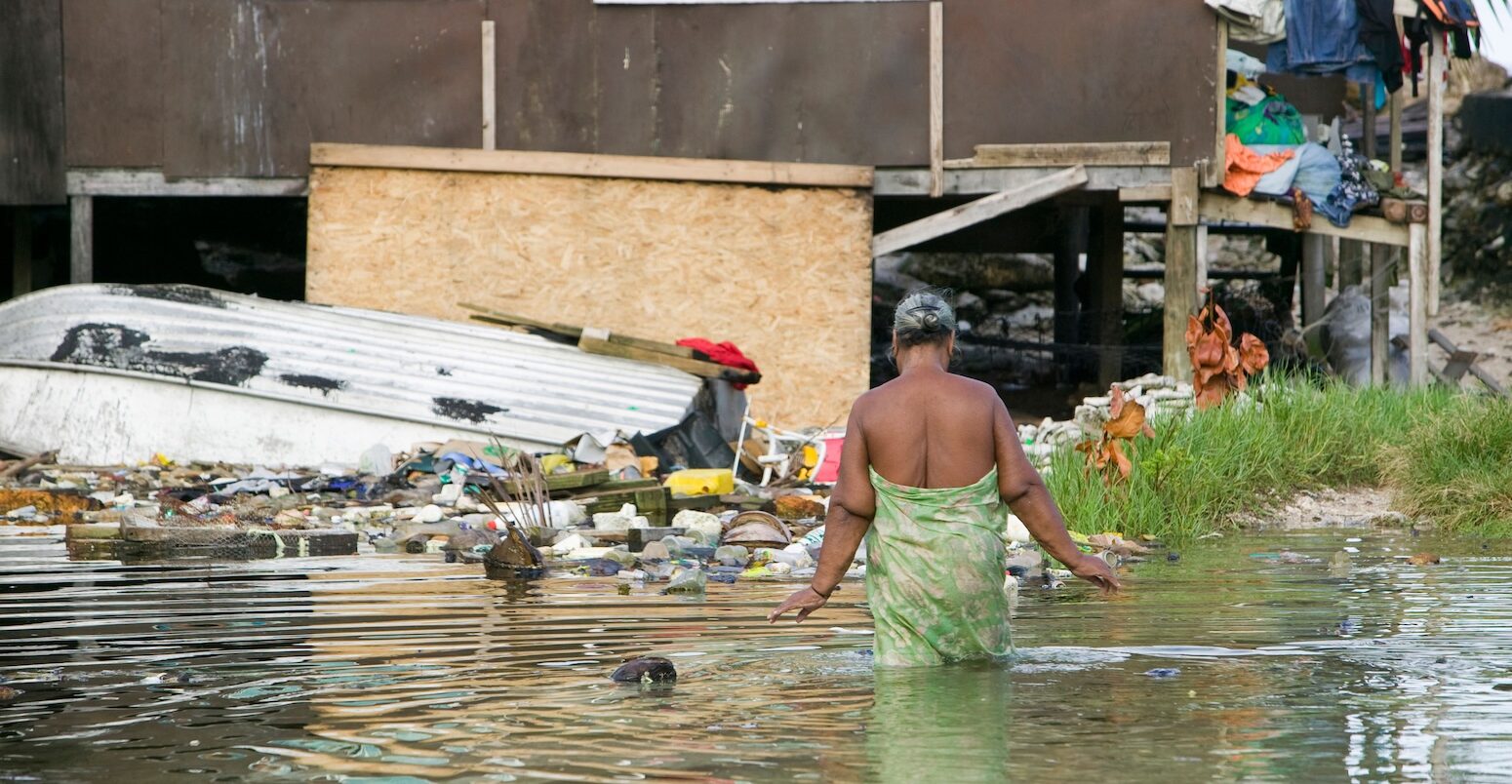 A woman wades through flood water in Tuvalu.