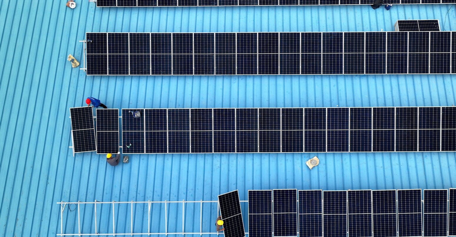 Workers install solar photovoltaic panels on the roof of a factory in Haian, Jiangsu province on 11 April 2024.