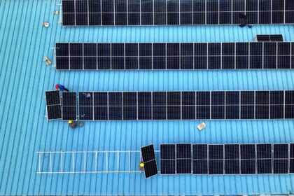 Workers install solar photovoltaic panels on the roof of a factory in Haian, Jiangsu province on 11 April 2024.