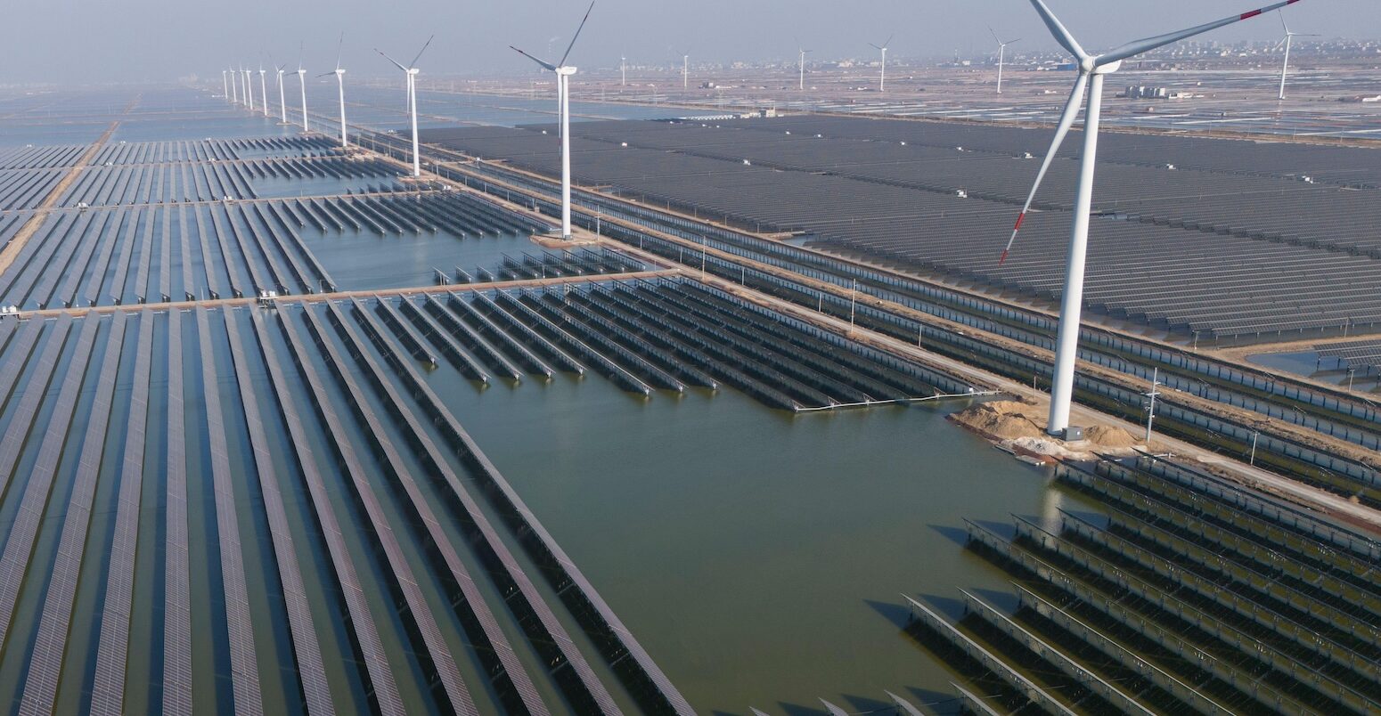 Wind turbines dot the coast line along a giant solar farm near Weifang in eastern China's Shandong province on 22 March 2024.