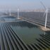 Wind turbines dot the coast line along a giant solar farm near Weifang in eastern China's Shandong province on 22 March 2024.