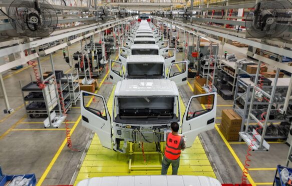 An employee operates at an assembly line of new energy light trucks in Guizhou, China.