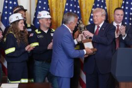 President Donald Trump is presented a trophy by Jim Grech, president and CEO of Peabody Energy and chair of the National Coal Council (NCC), during an event on coal power in the East Room of the White House, Wednesday, Feb. 11, 2026, in Washington.