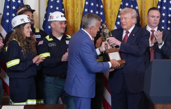 President Donald Trump is presented a trophy by Jim Grech, president and CEO of Peabody Energy and chair of the National Coal Council (NCC), during an event on coal power in the East Room of the White House, Wednesday, Feb. 11, 2026, in Washington.