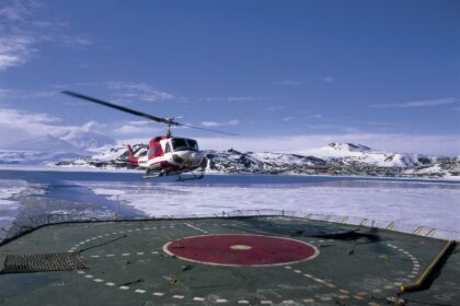 Helicopter landing on icebreaker deck near US scientific research base on Ross Island, Antarctica. Image ID: A1E4K4