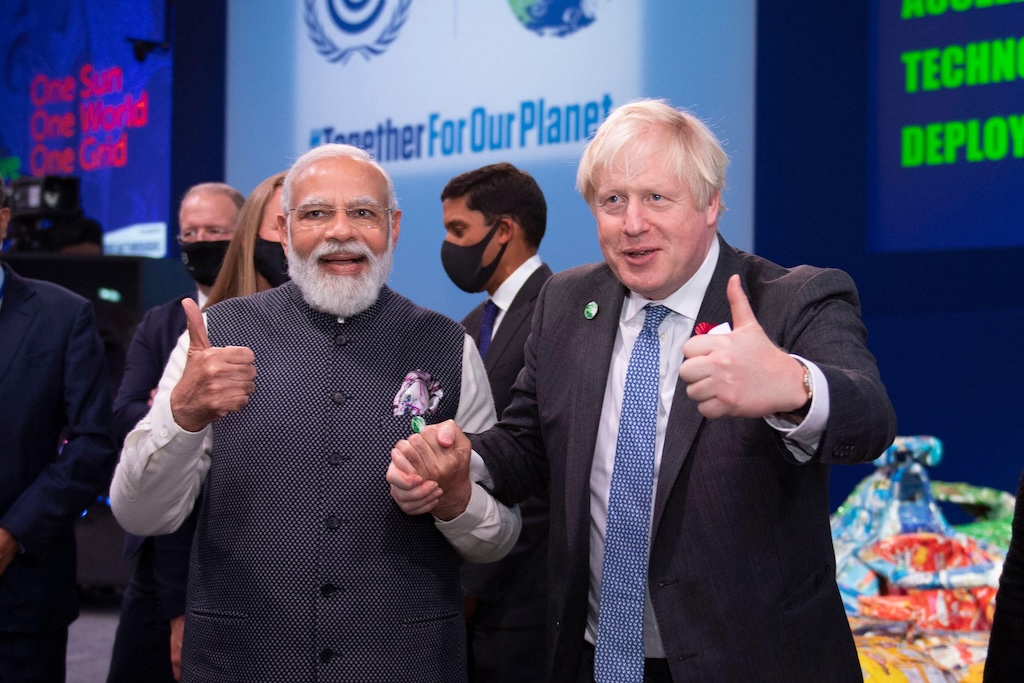 India’s prime minister Narendra Modi holds hands with thenformer UK prime minister Boris Johnson at COP26 in Glasgow, where Modi announced India’s net-zero target. Credit: Colin Fisher / Alamy Stock Photo. Image ID: 2H4GC7C.