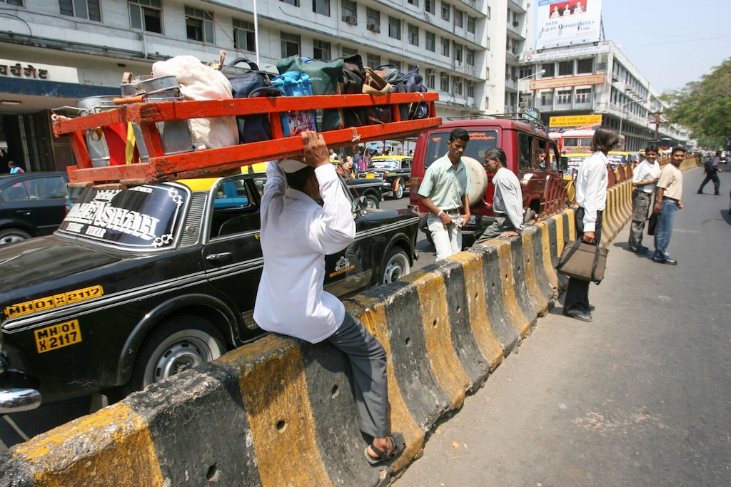 A dabbawallah balances hot tiffins to take to office workers in the south of Mumbai. Credit: Alamy Stock Photo