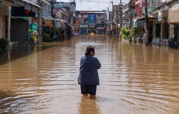 A resident walks through inundated streets in Nong Khai city, Thailand