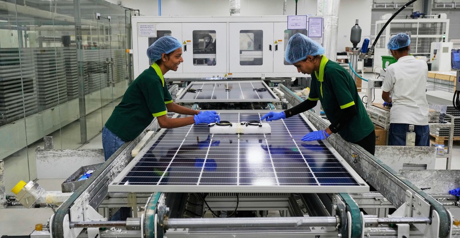 Workers put switches and connectors on solar panels at a factory in Jaipur, India.