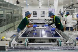 Workers put switches and connectors on solar panels at a factory in Jaipur, India.