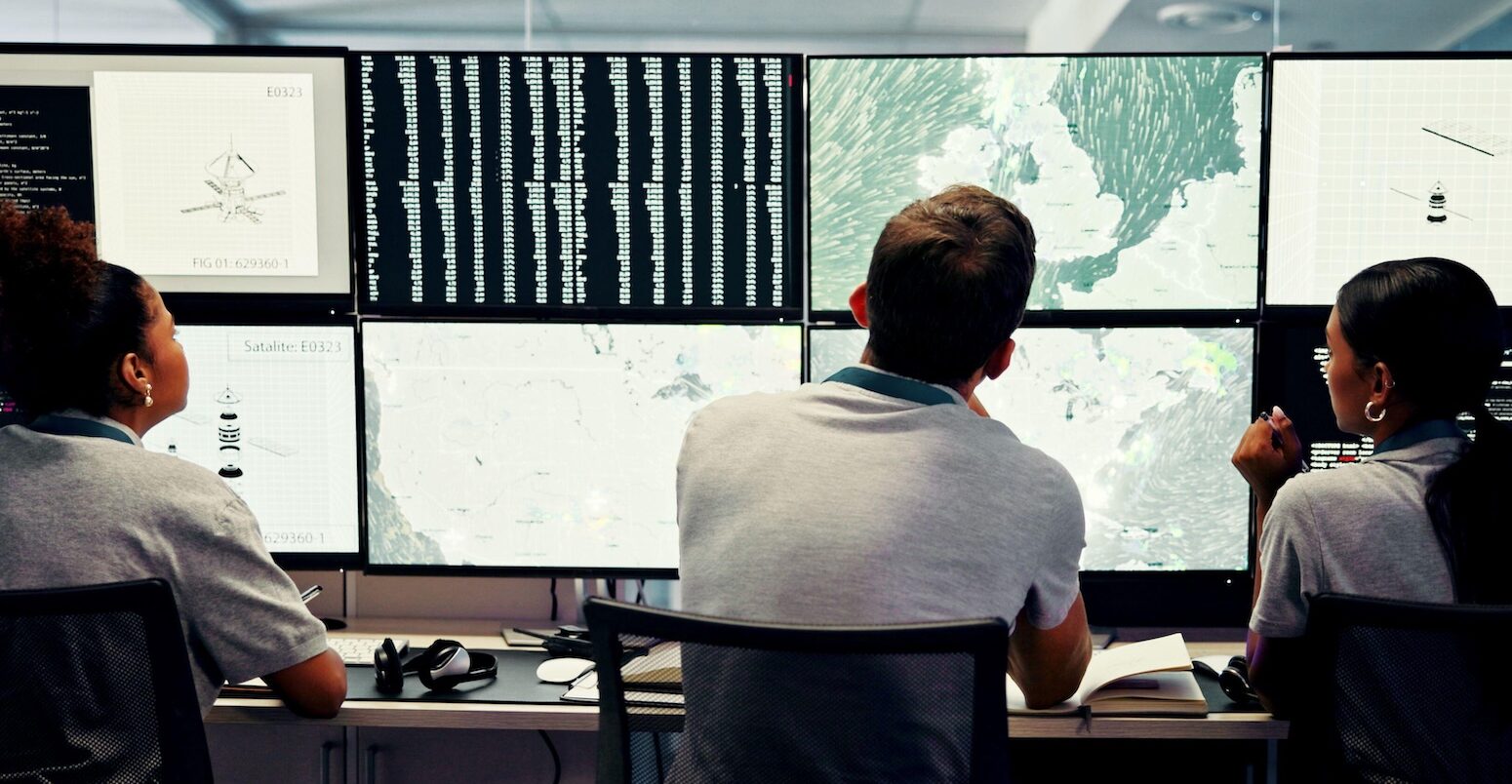 Scientists track weather data in a control room.