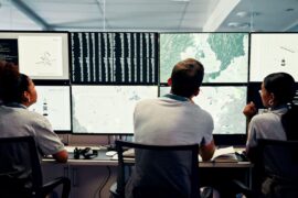 Scientists track weather data in a control room.