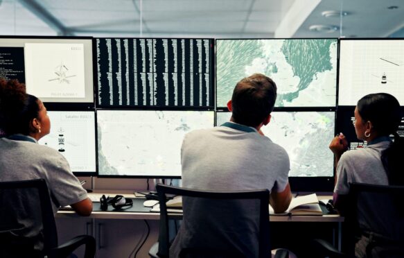 Scientists track weather data in a control room.