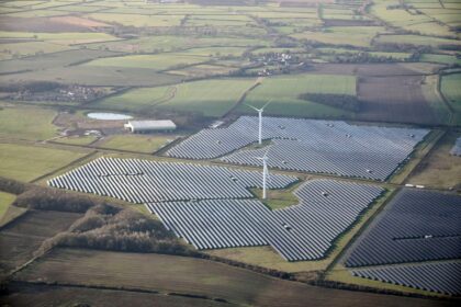 Aerial view of a solar farm and wind turbines, in the East Midlands, UK.