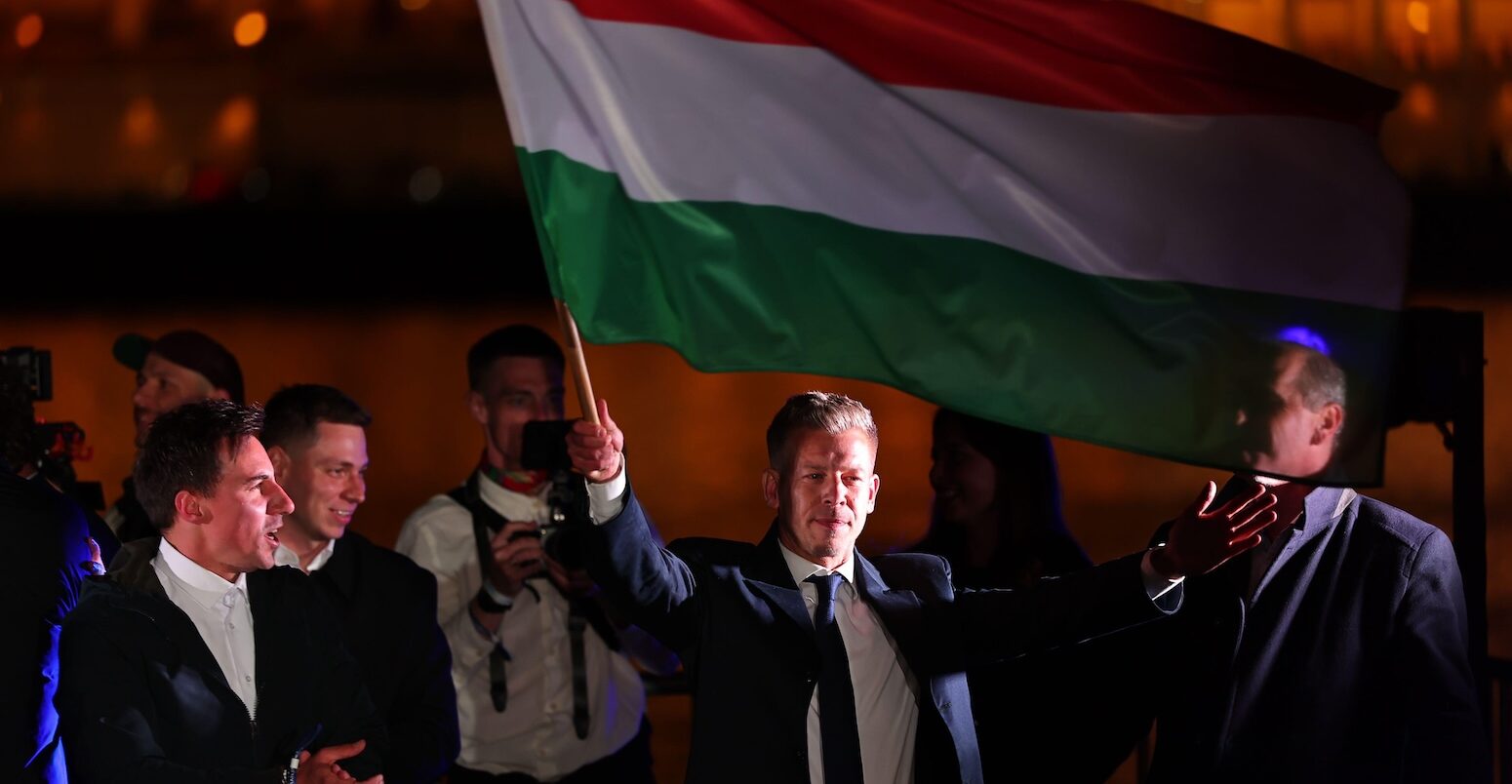 Peter Magyar, leader of Hungary's Tisza Party, waves the Hungarian national flag at an election victory rally.