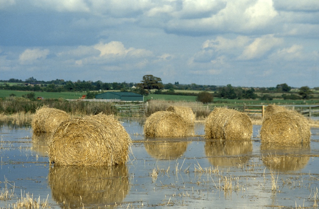Flooded fields with hay bails on farmland on the Somerset Levels.