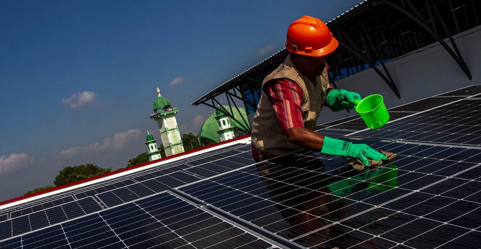 A worker cleans the surface of a solar panel in Central Java, Indonesia.