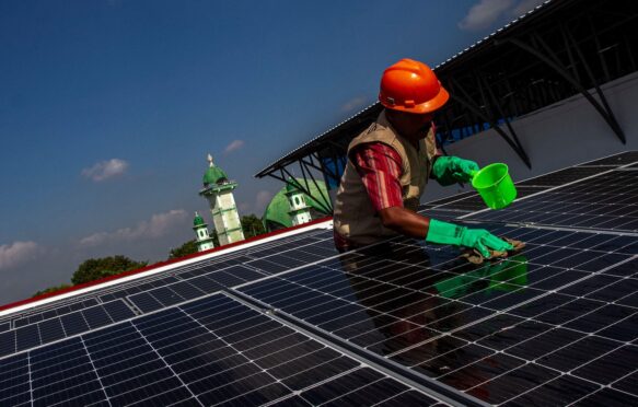 A worker cleans the surface of a solar panel in Central Java, Indonesia.