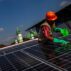 A worker cleans the surface of a solar panel in Central Java, Indonesia.