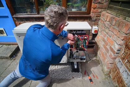 Engineer installing a heat pump, UK.