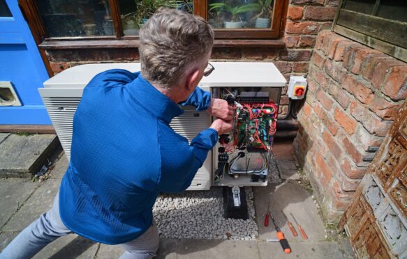 Engineer installing a heat pump, UK.