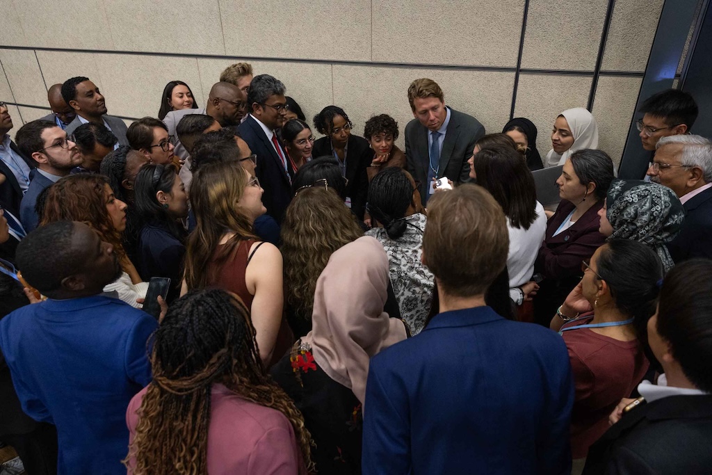 Delegates huddle during the informal consultations on the Global Goal on Adaptation