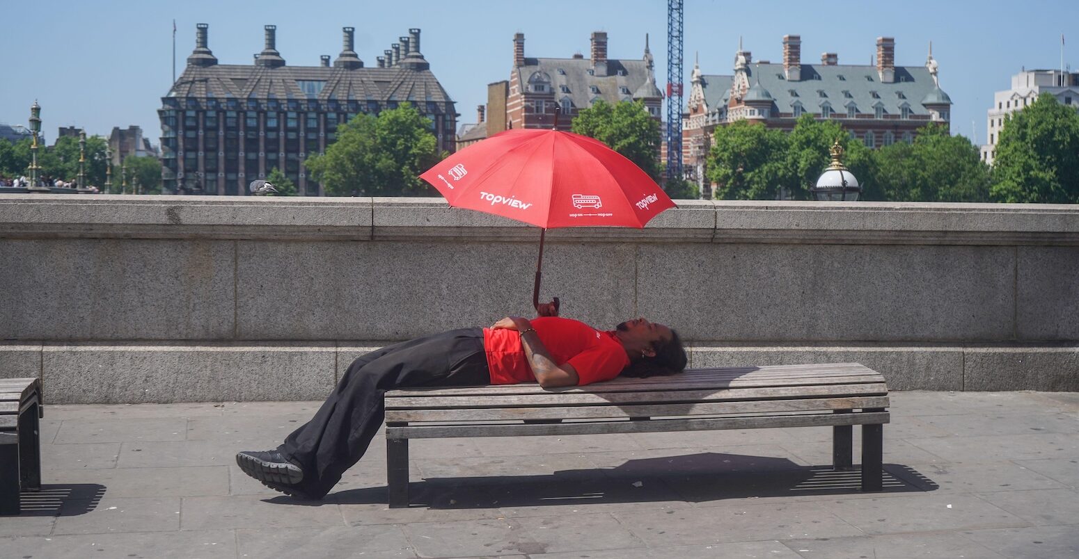 Person sheltering underneath an umbrella during the heatwave in London on 26 May 2026.