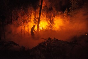 A firefighter battles a wildfire in southwestern France on 26 July 2026.