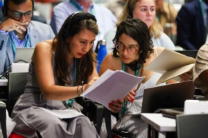 Delegates studying documents at UN biodiversity summit, COP16, in Cali, Colombia.